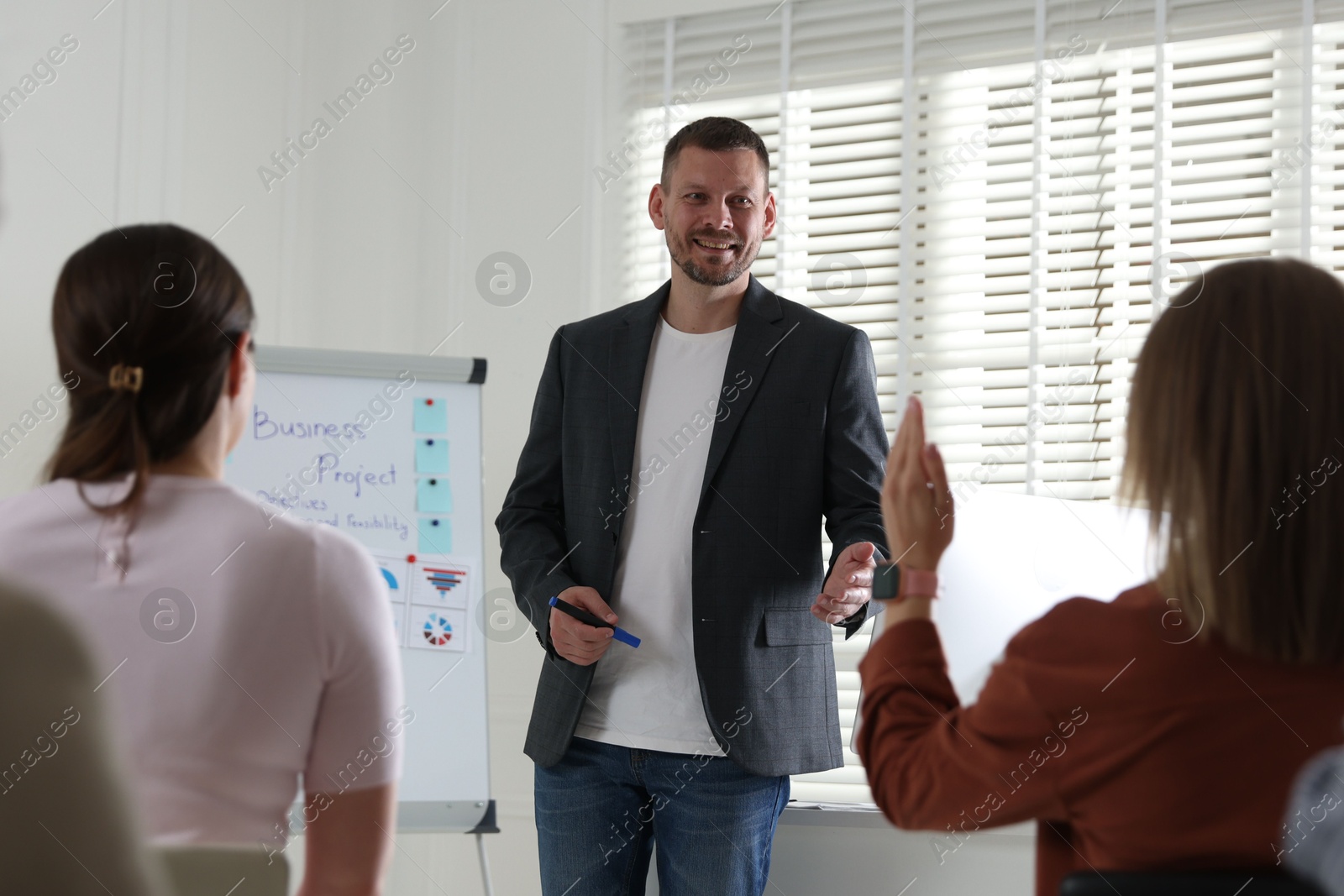 Man giving public speech in front of audience indoors Photo of Man giving public speech in front of audience indoors