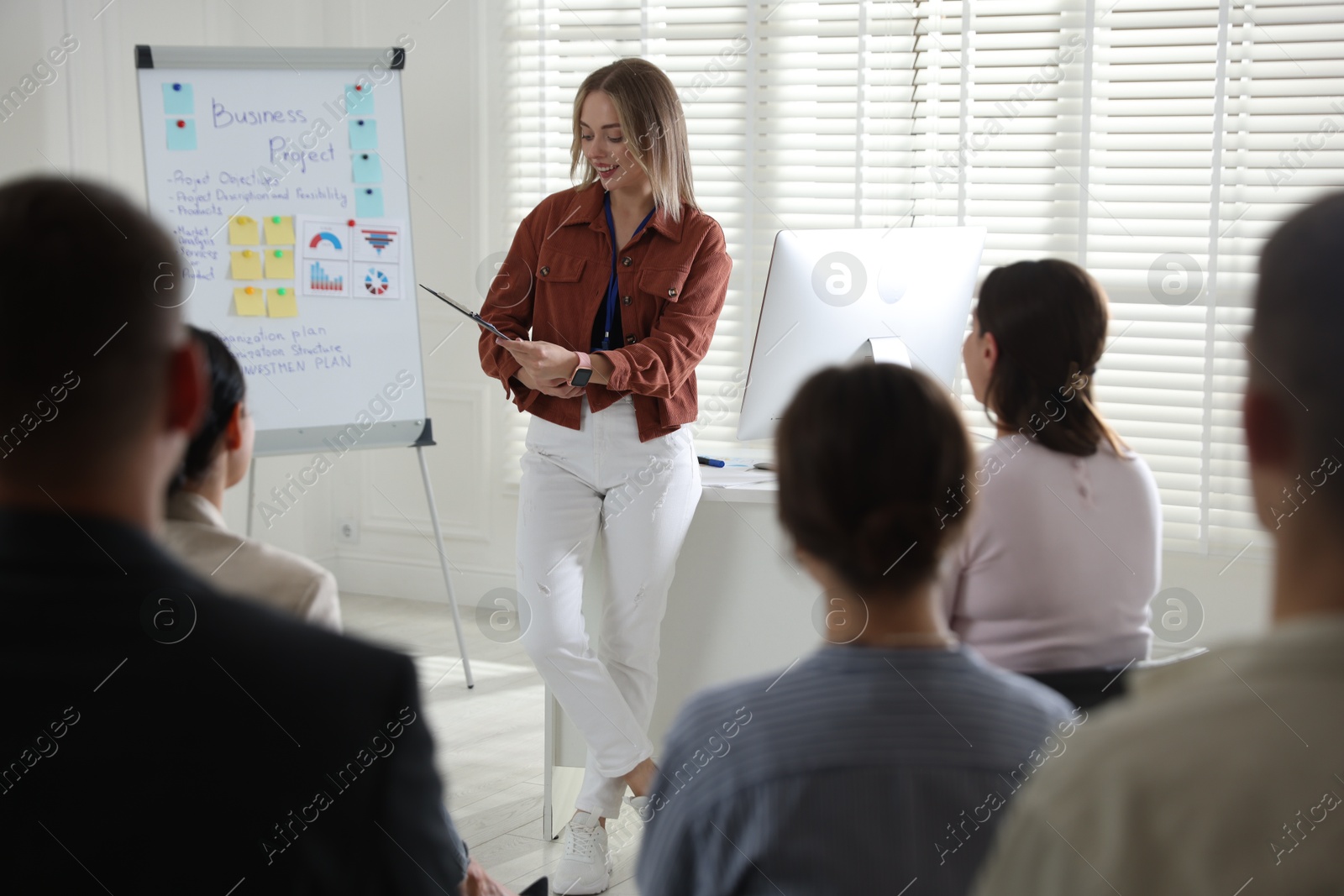 Woman giving public speech in front of audience indoors Photo of Woman giving public speech in front of audience indoors