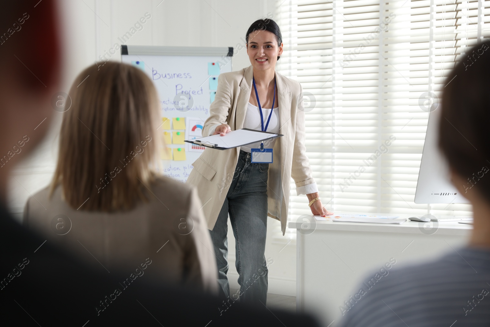 Woman giving public speech in front of audience indoors Photo of Woman giving public speech in front of audience indoors