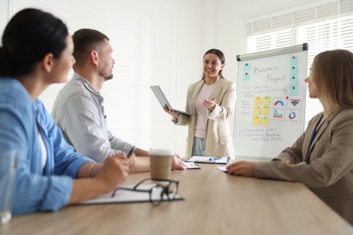 Photo of Woman giving public speech in front of audience indoors
