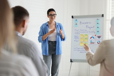 Photo of Woman giving public speech in front of audience indoors