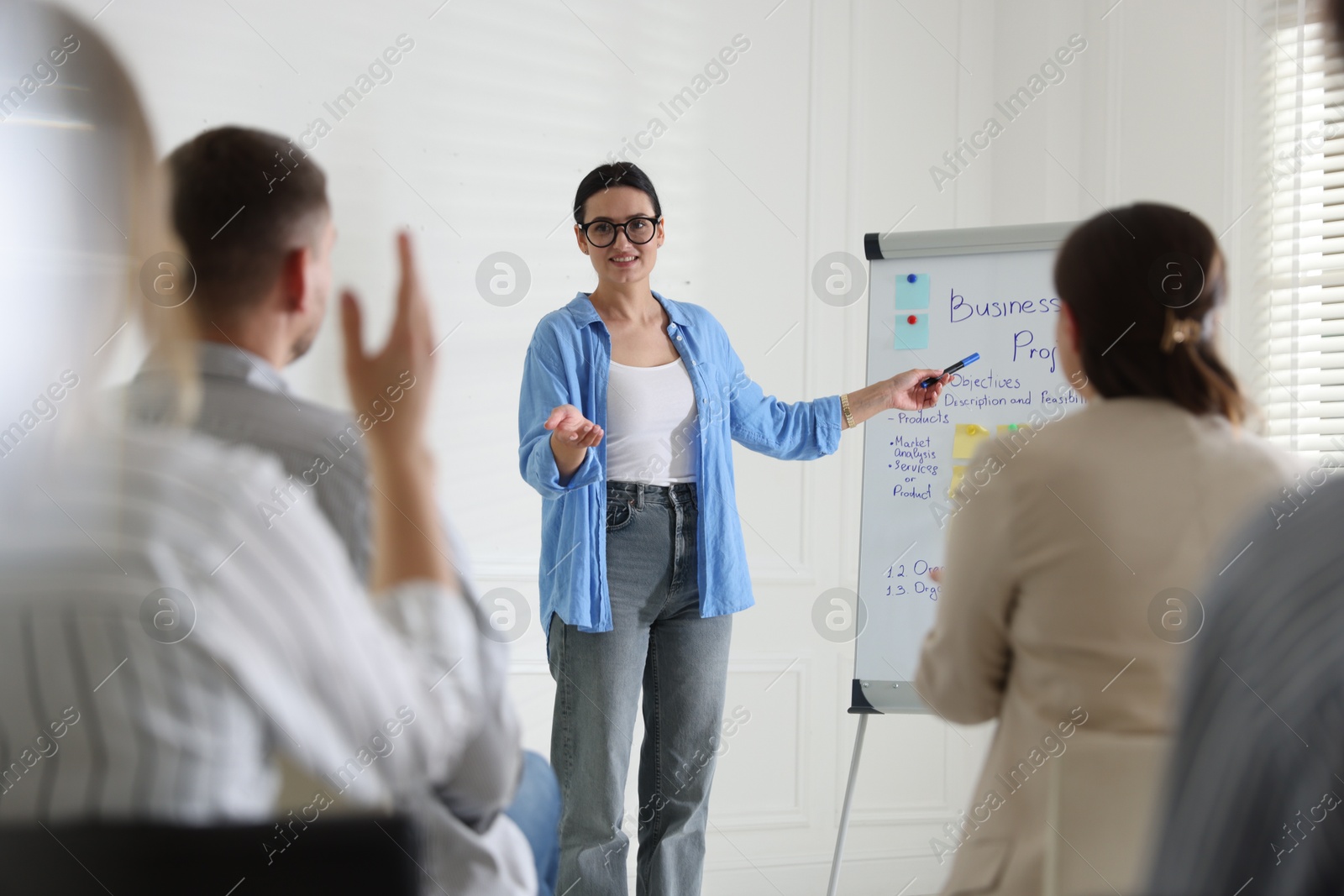 Woman giving public speech in front of audience indoors Photo of Woman giving public speech in front of audience indoors