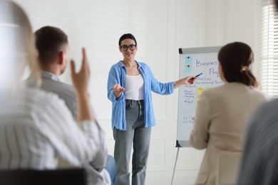 Photo of Woman giving public speech in front of audience indoors