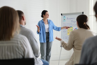 Photo of Woman giving public speech in front of audience indoors