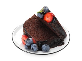 Photo of Pieces of delicious chocolate bundt cake with strawberries and blueberries isolated on white