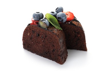 Photo of Pieces of delicious chocolate bundt cake with strawberries, mint and blueberries isolated on white