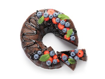 Photo of Delicious chocolate bundt cake with strawberries, mint and blueberries isolated on white, top view