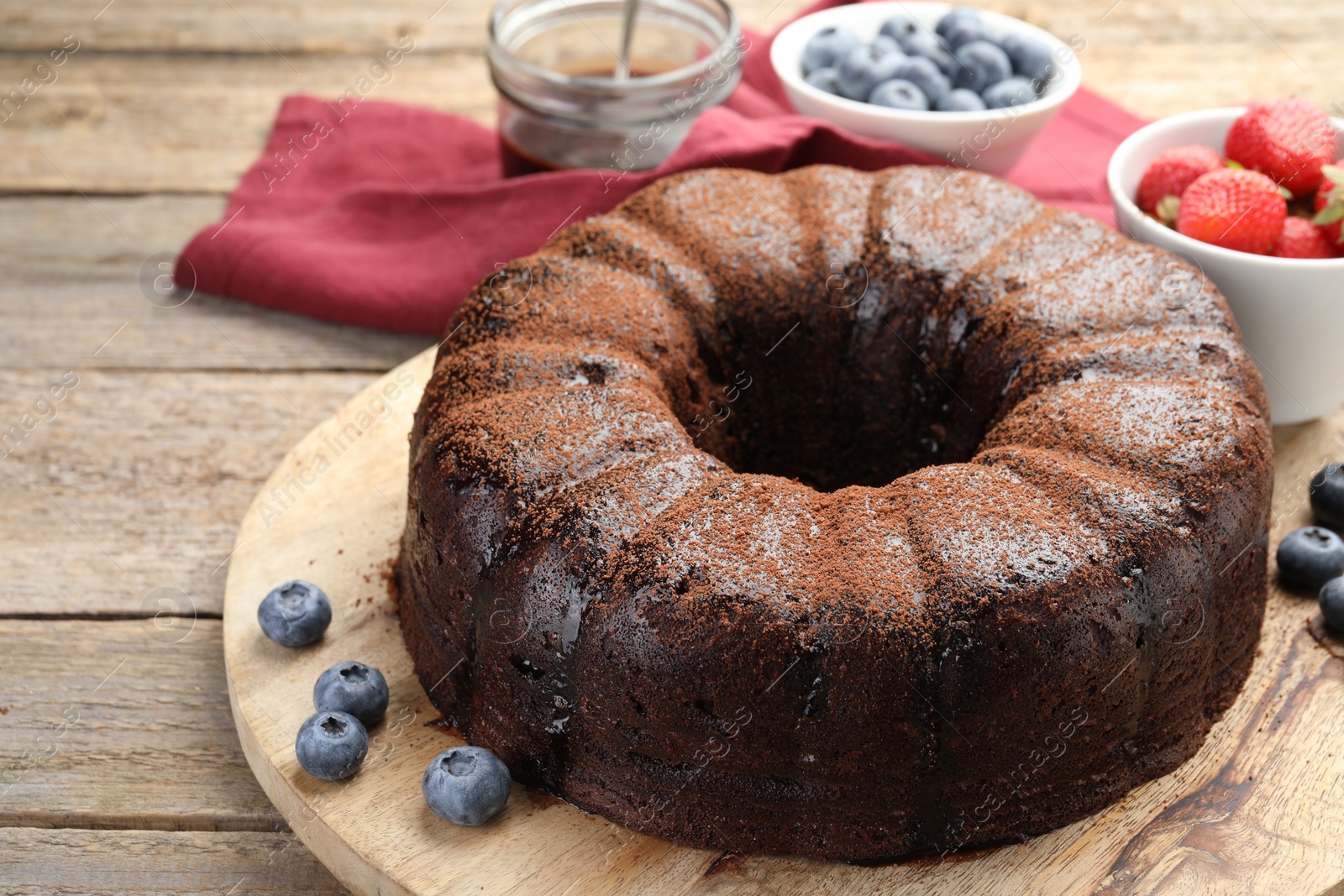 Delicious chocolate bundt cake with blueberries on wooden table, closeup Photo of Delicious chocolate bundt cake with blueberries on wooden table, closeup