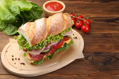 Photo of Tasty baguette sandwich with ham and vegetables on wooden table, closeup. Space for text