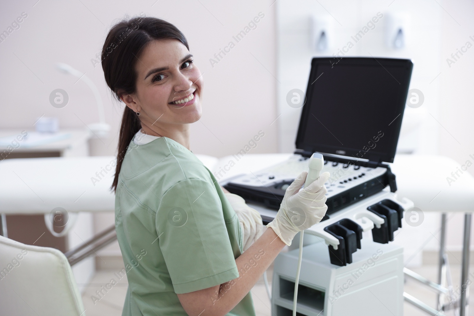 Professional sonographer with ultrasound machine in clinic Photo of Professional sonographer with ultrasound machine in clinic