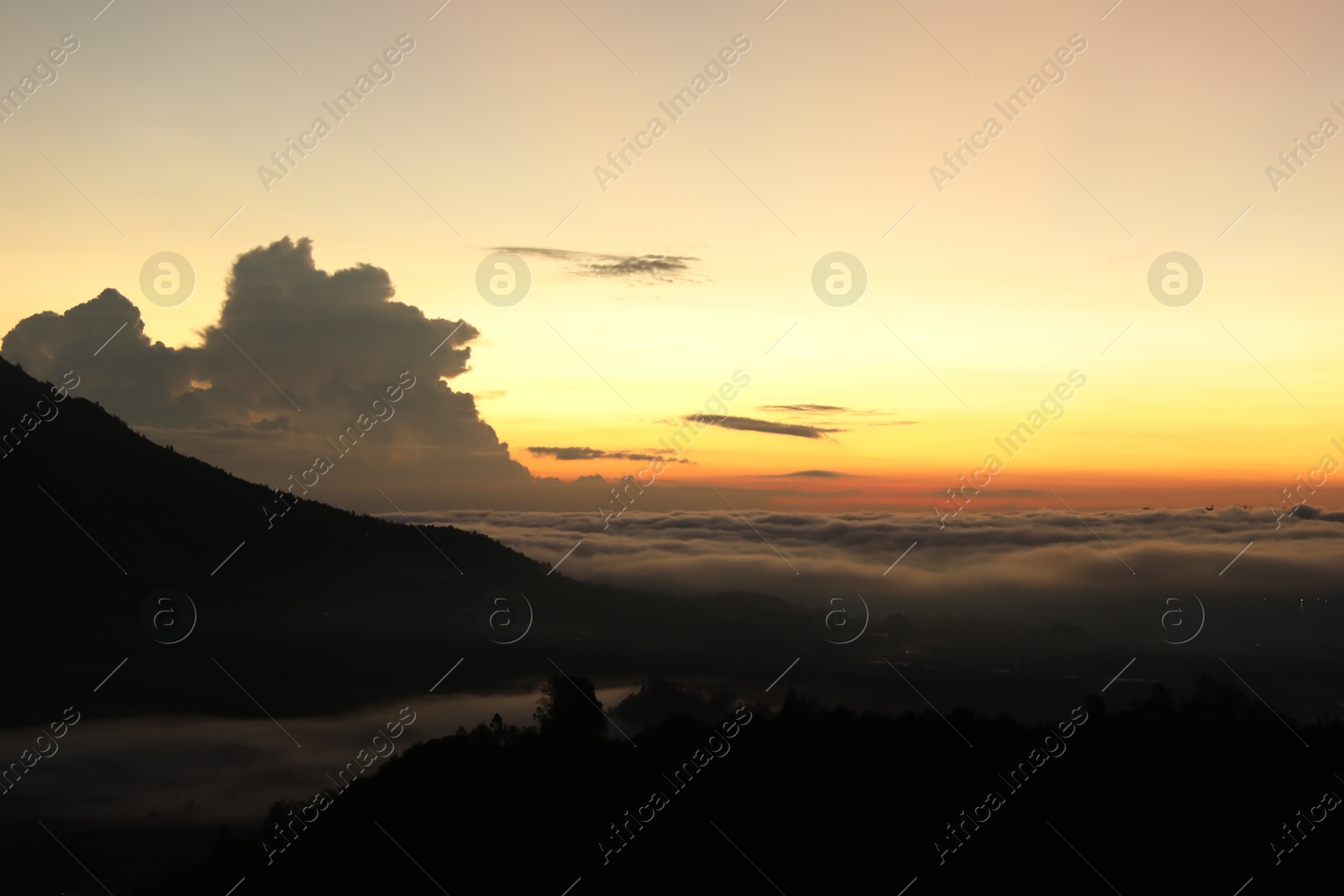 Picturesque view of mountains covered with fog on sunset Photo of Picturesque view of mountains covered with fog on sunset