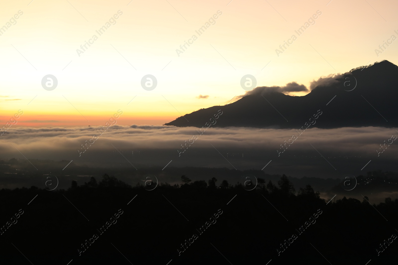 Picturesque view of mountains covered with fog on sunset Photo of Picturesque view of mountains covered with fog on sunset