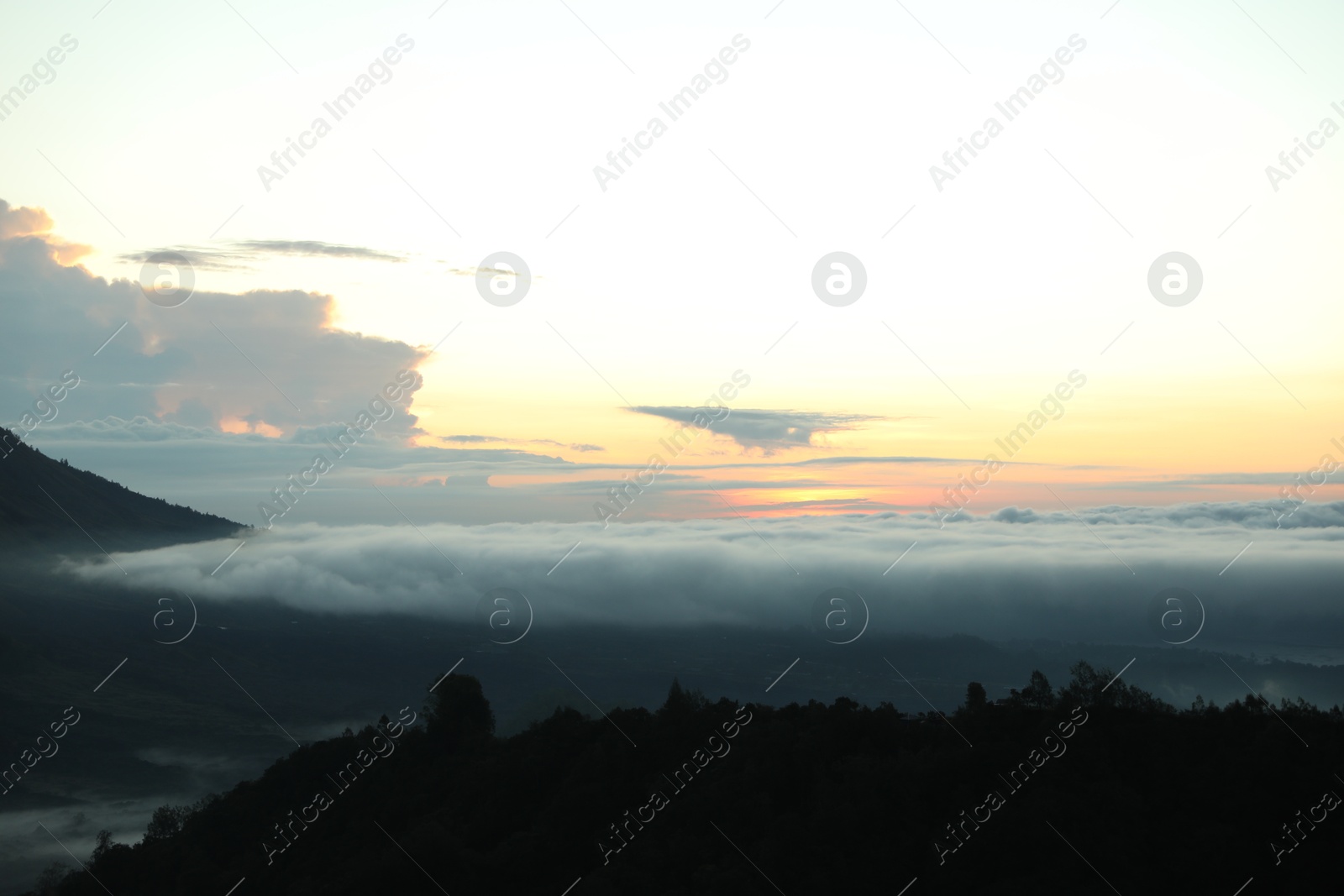 Picturesque view of mountains covered with fog on sunset Photo of Picturesque view of mountains covered with fog on sunset