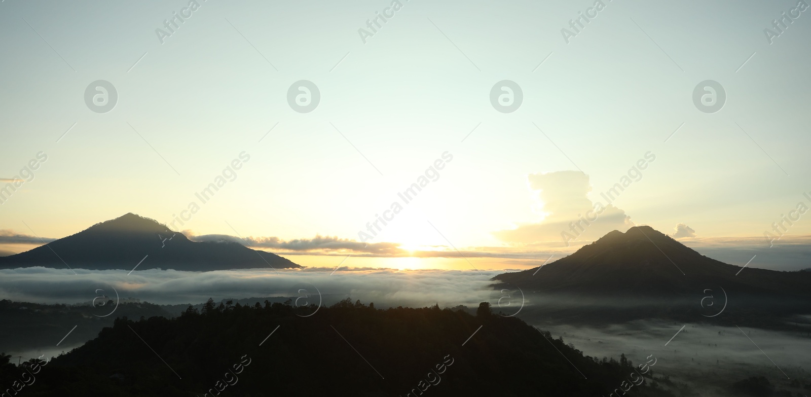 Picturesque view of mountains covered with fog on sunset Photo of Picturesque view of mountains covered with fog on sunset