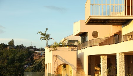Photo of Beautiful villa with balconies against blue sky. Space for text