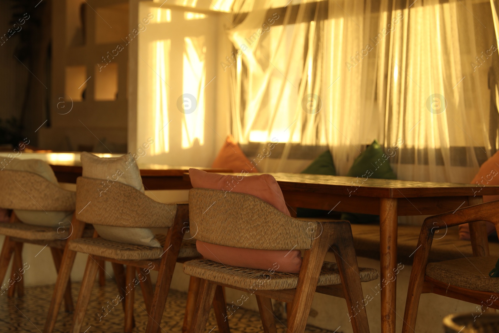 Wooden table and chairs near window indoors Photo of Wooden table and chairs near window indoors