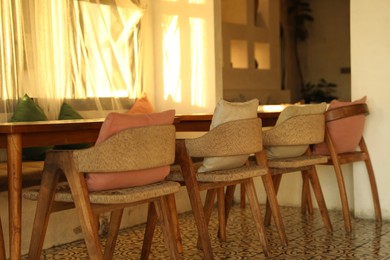 Photo of Wooden table and chairs near window indoors
