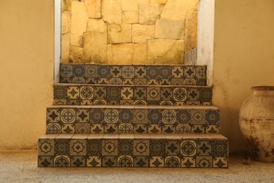 Photo of Stairs decorated with beautiful tiles near entrance indoors
