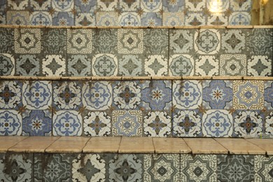 Photo of Stairs decorated with beautiful tiles indoors, closeup