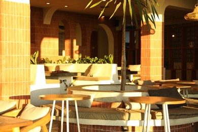 Photo of Stylish tables and empty benches in cafe