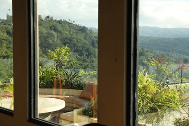 Photo of View through window on backyard and beautiful mountains
