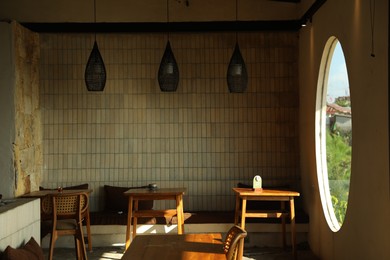 Photo of Stylish cafe with wooden furniture and big round window