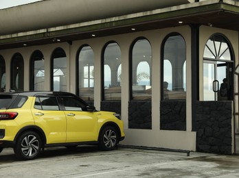Photo of Yellow car parked near shop on city street