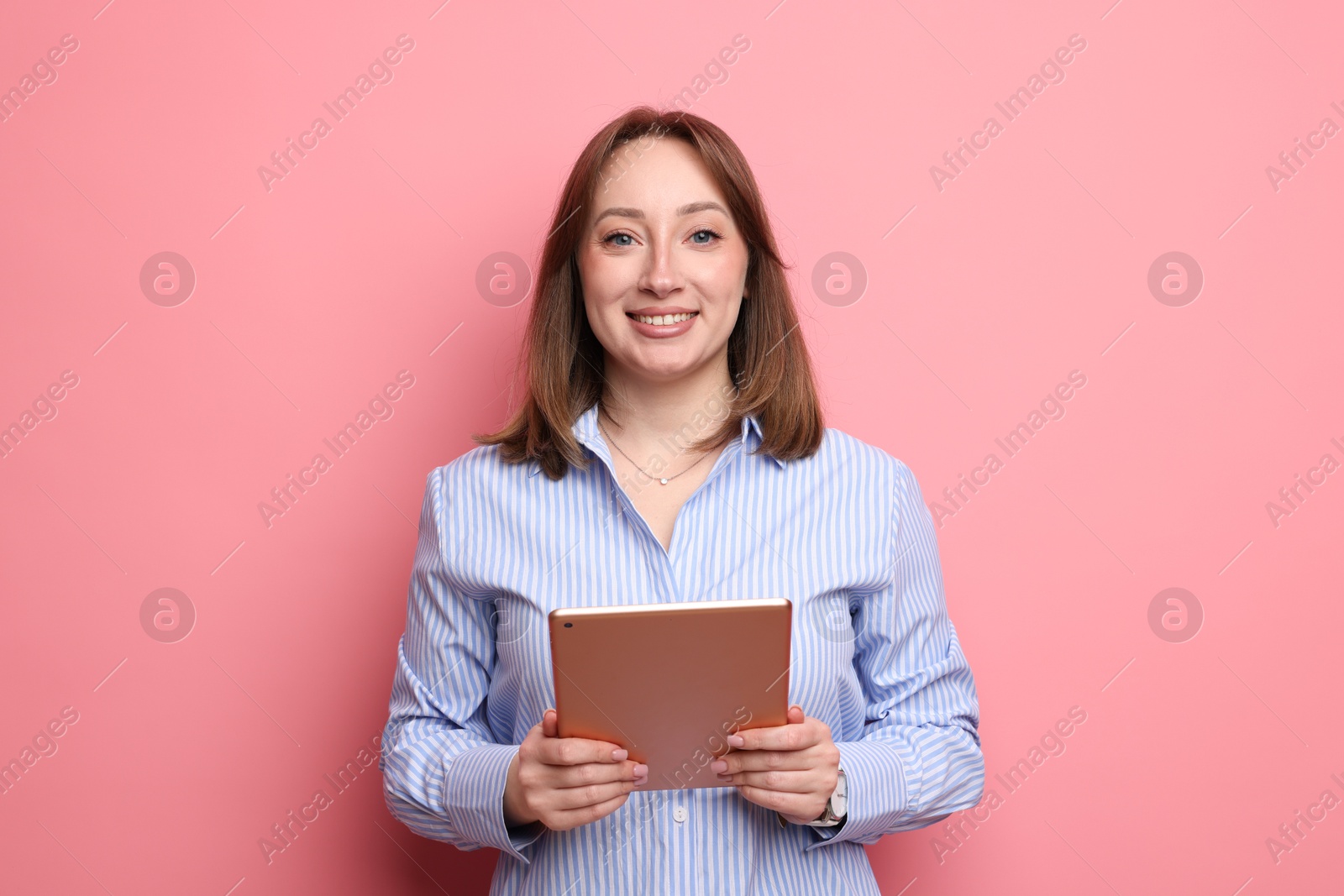 Woman with modern tablet on pink background Photo of Woman with modern tablet on pink background