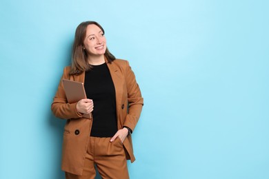 Photo of Woman with modern tablet on light blue background, space for text