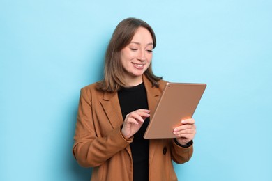 Photo of Woman with modern tablet on light blue background