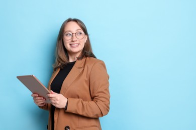 Photo of Woman with modern tablet on light blue background, space for text