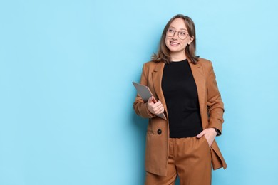 Photo of Woman with modern tablet on light blue background, space for text