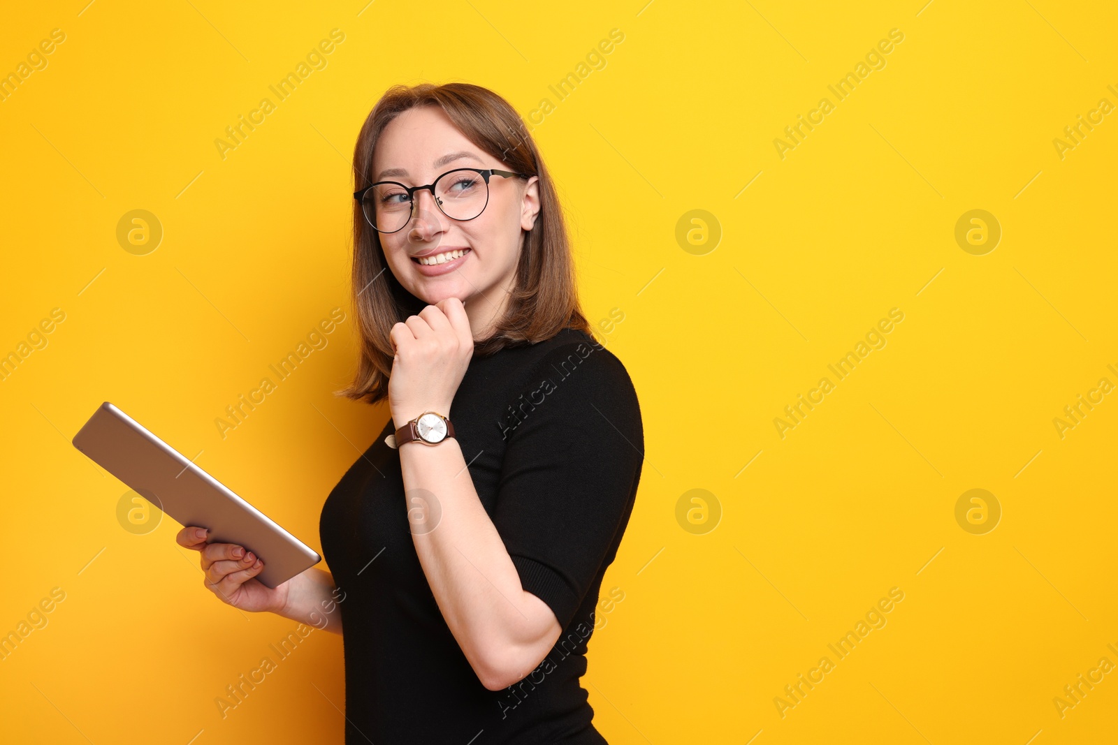 Woman with modern tablet on orange background, space for text Photo of Woman with modern tablet on orange background, space for text