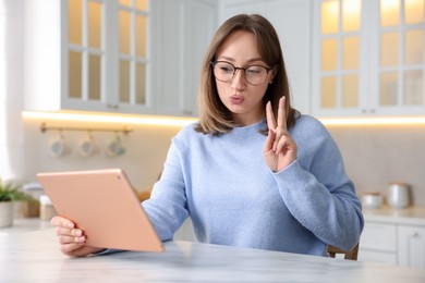 Photo of Woman taking selfie at white marble table in kitchen