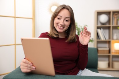 Photo of Woman having video chat via on sofa at home