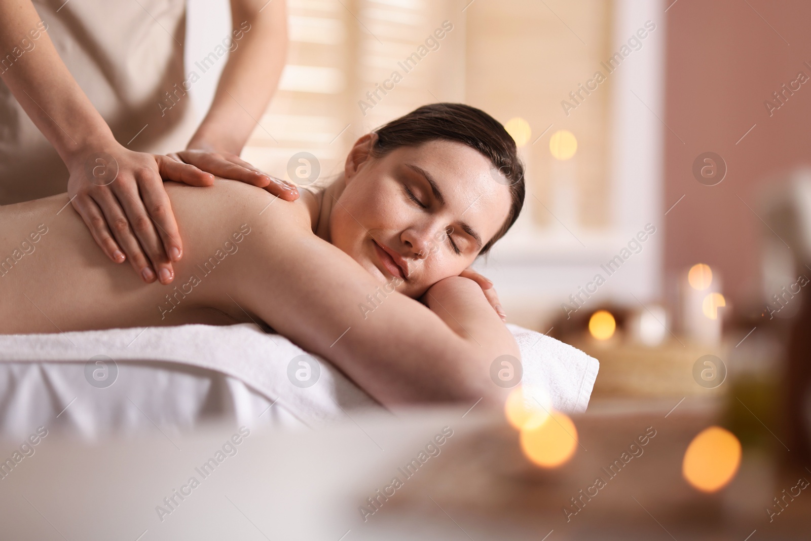 Woman receiving back massage with oil in spa salon, space for text Photo of Woman receiving back massage with oil in spa salon, space for text