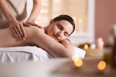 Photo of Woman receiving back massage with oil in spa salon, space for text