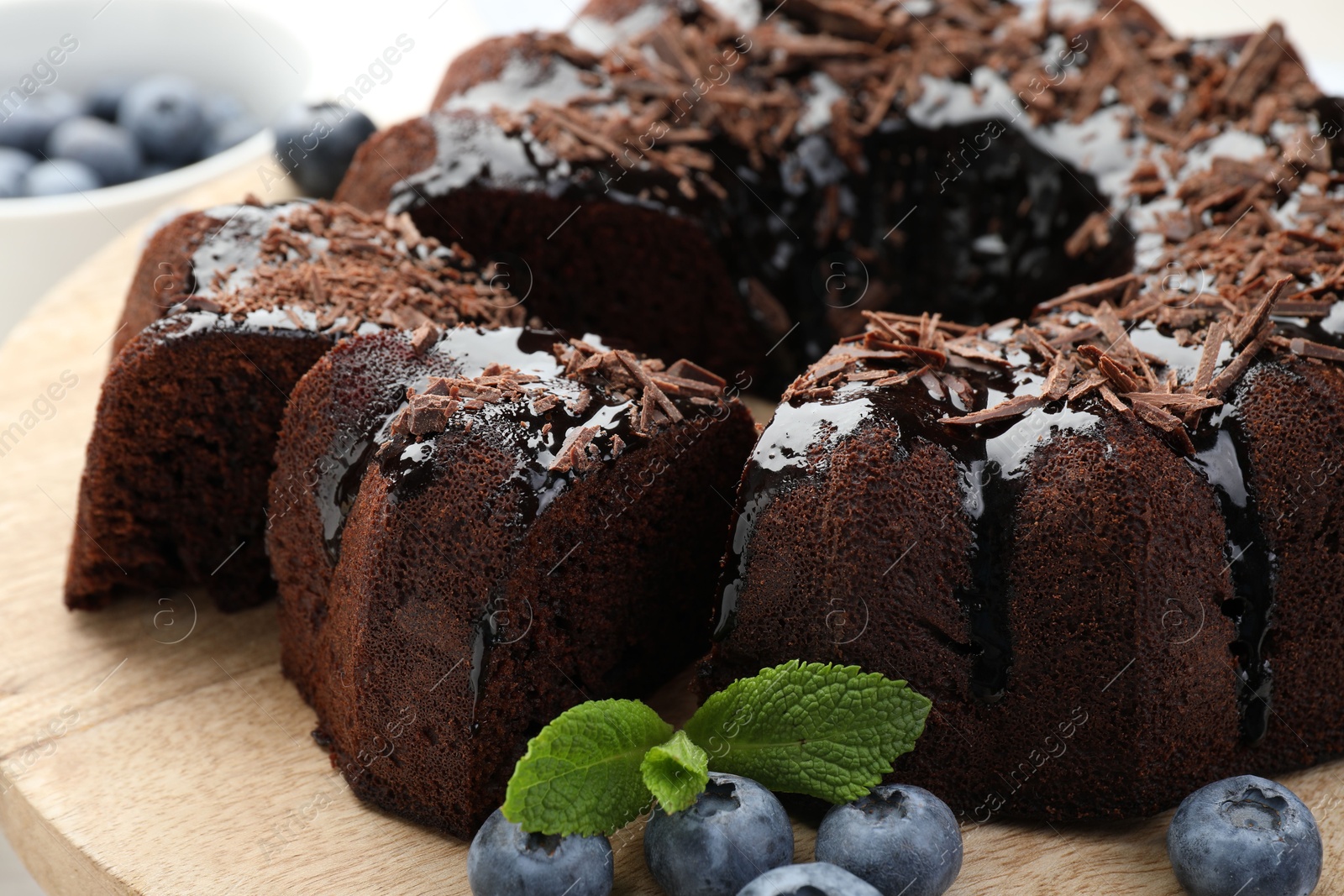 Delicious bundt cake with blueberries, mint and chocolate shavings on table, closeup Photo of Delicious bundt cake with blueberries, mint and chocolate shavings on table, closeup