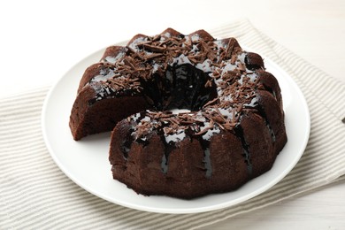 Photo of Delicious chocolate bundt cake on light wooden table, closeup