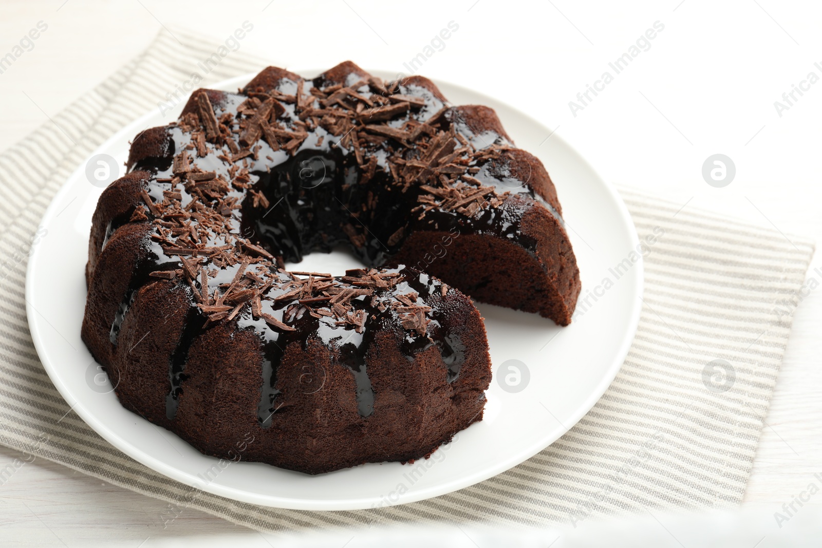 Delicious chocolate bundt cake on light wooden table, closeup Photo of Delicious chocolate bundt cake on light wooden table, closeup