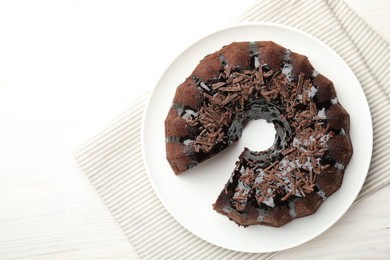 Photo of Delicious chocolate bundt cake on light wooden table, top view. Space for text