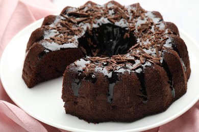 Photo of Delicious chocolate bundt cake and napkin on table, closeup