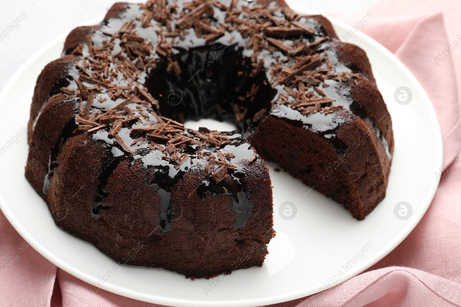 Delicious chocolate bundt cake and napkin on table, closeup Photo of Delicious chocolate bundt cake and napkin on table, closeup