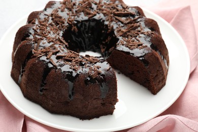 Photo of Delicious chocolate bundt cake and napkin on table, closeup