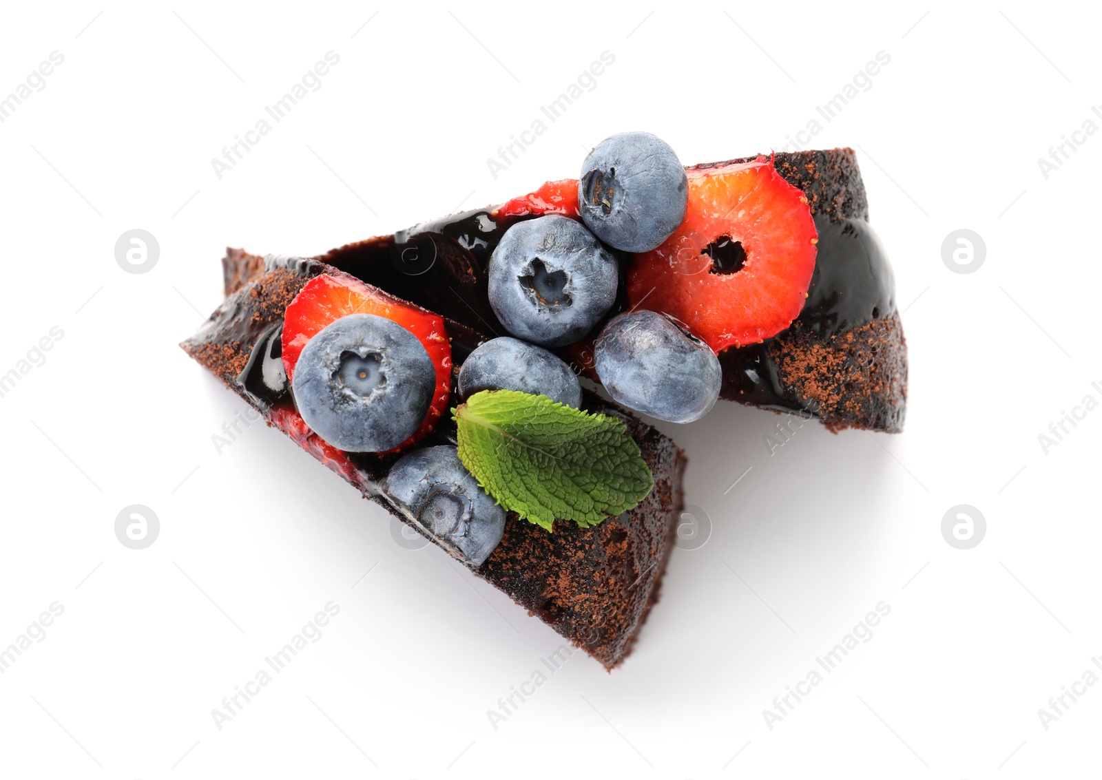 Photo of Pieces of delicious chocolate bundt cake with strawberries and blueberries isolated on white, top view