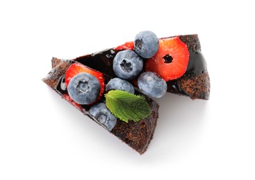 Photo of Pieces of delicious chocolate bundt cake with strawberries and blueberries isolated on white, top view