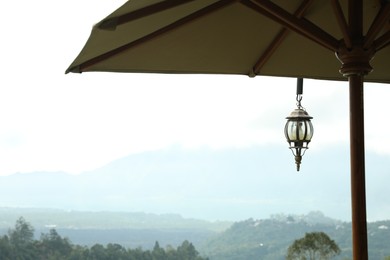 Photo of Big umbrella against beautiful mountain landscape, closeup