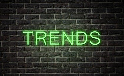 Image of Neon sign with word Trends on black brick wall