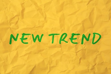 Image of New Trend. Words on crumpled yellow sheet of paper