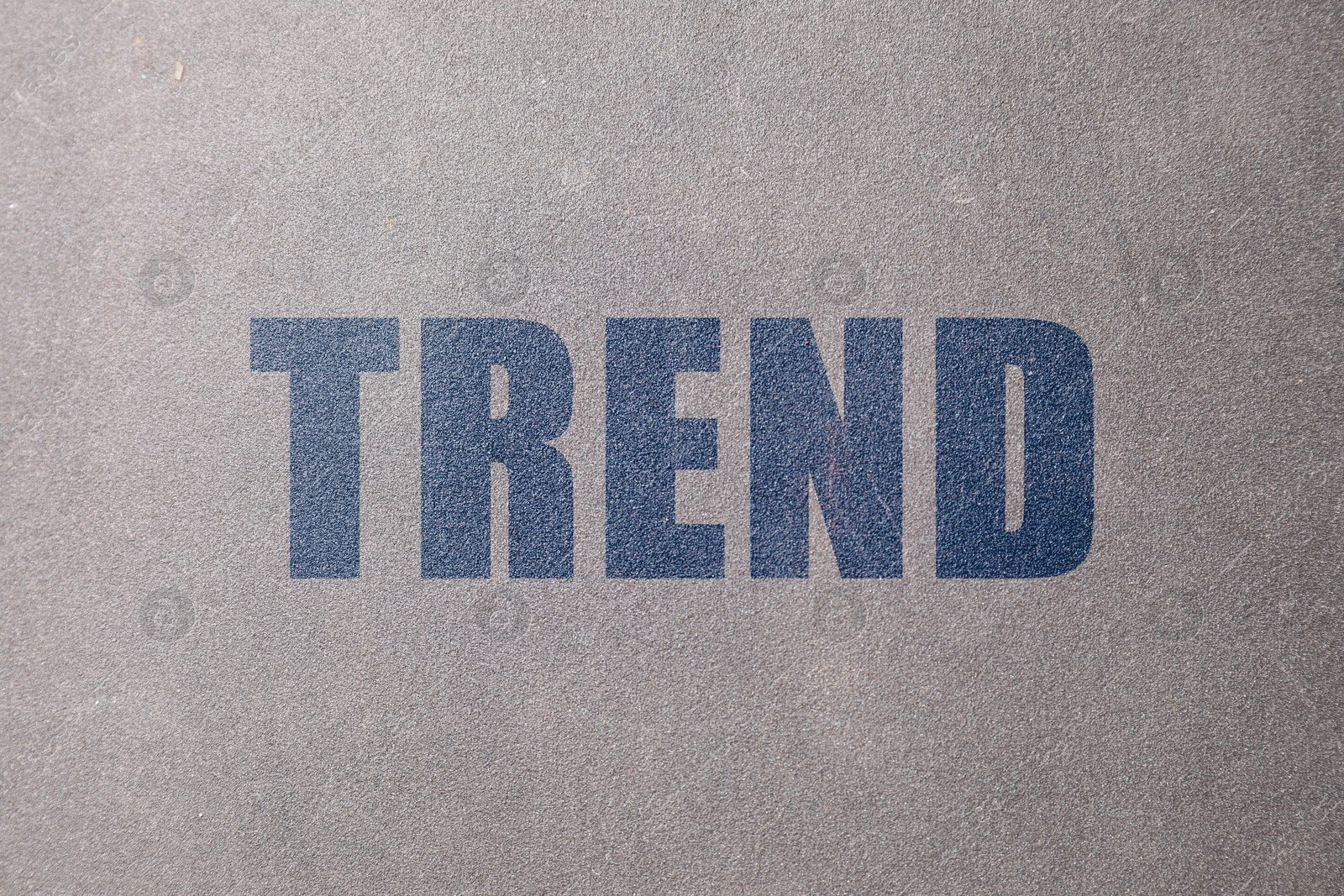 Trend. Blue word on grey textured background Image of Trend. Blue word on grey textured background